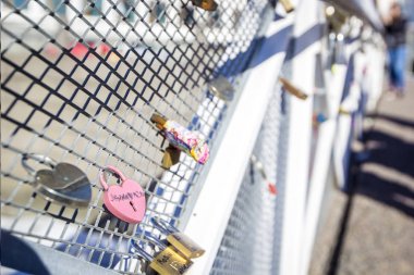 Aşk kilitleri asılı bir beyaz metal yaya köprüsü, Helsinki, Finlandiya üzerinden. Sığ alan derinliği ve bokeh.