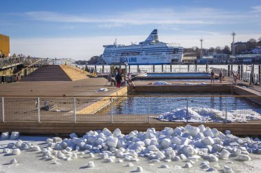 Helsinki, Finlandiya - Marh 30, 2018: Röpotajlar deniz havuzu - spa / deniz sıcak su ve saunalar için ile büyük havuzlu sağlık hub kış güneşli gün, yolcu feribotu arka planda, Finlandiya Güney Harbour Helsinki oteli, sakin ol.