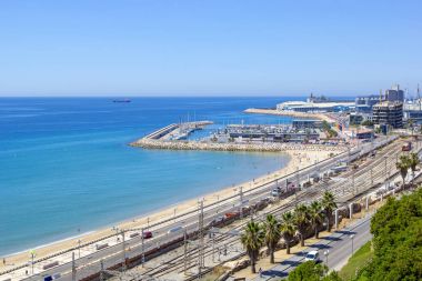 Tarragona sahil panoramik manzaralı, kıyı şeridi ve bağlantı noktası ile gemiler ve yatlar, Tarragona, Catalunya, İspanya boyunca La Pineda Beach'te demiryolu ile güneşli günde izler