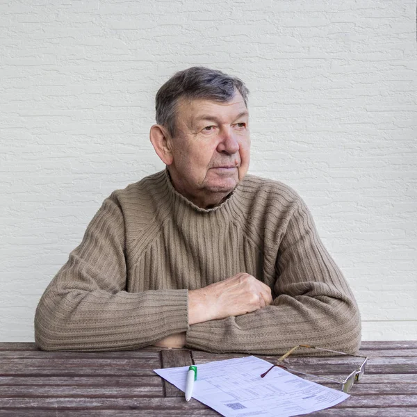 Портрет Пожилого Человека Сидящего Столом Белым Листом Бумаги Ручкой Очками — стоковое фото