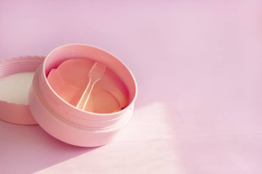 Pembe arka planda cilt bakımı için hidrojel kozmetik göz bandı. Yüz gerdirme için ürün, yaşlanma önleyici kırışıklıklar, kopyalama alanı