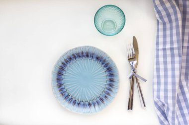 Deniz usulü masa hazır. Mavi boş tabaklar, cam, çatal ve bıçak çizgili peçetelerin üzerinde. Masa düzenine hazırlık. Düz konum, üst görünüm, kopyalama alanı