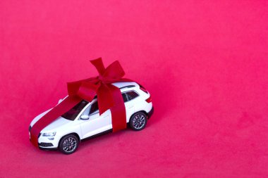 St. Petersburg, Rusya - 3 Aralık 2019: Kırmızı arka planda kırmızı pruva olan yeni oyuncak araba hediyesi. Konsept kiralama, oto galerisi, kopyalama alanı
