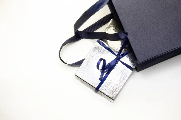 ギフト紙バッグ ショッピングバッグ銀ギフトボックス付き青弓リボンで青色で隔離された白い背景 ブランククラフトパッケージのモックアップ 父の日を提示するための概念 — ストック写真