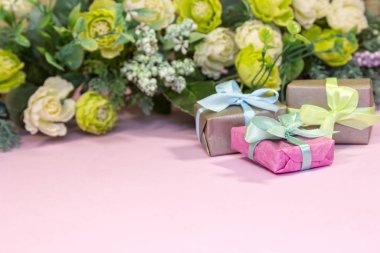 Gül buketi ve pembe arka planda hediye kutusu. Sevgililer Günü kavramı, annelerin bayramı, düğün veya 8 Mart tebrik kartı