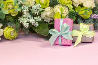 Gül buketi ve pembe arka planda hediye kutusu. Sevgililer Günü kavramı, annelerin bayramı, düğün veya 8 Mart tebrik kartı