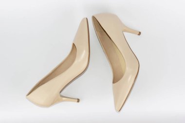 Yüksek topuklu beyaz arka planda izole edilmiş bej kadın deri ayakkabıları. Kadın alışverişi ve moda kavramı.