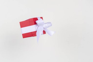 Beyaz arka planda uçan saten kurdeleli kırmızı hediye kutusu. Noel tatili, doğum günü, sevgililer günü, alışveriş ve satış için en düşük konsept.