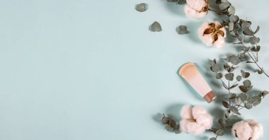 Kozmetik Spa ürünleri - krem kavanozu, okaliptüs yaprakları, pamuk çiçekler, hafif arka planda pedler. Doğal organik cilt ürünleri, en az tarzda, pankartta. Düz konum, üst görünüm, kopyalama alanı