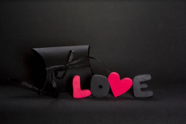 Schwarze Geschenkbox Und Rotes Wort Liebe Auf Dunklem Hintergrund Kopierraum — Stockfoto