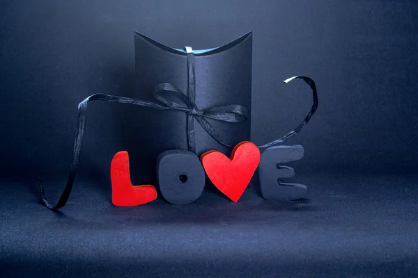 Schwarze Geschenkschachtel Und Rote Buchstaben Liebe Auf Dunklem Hintergrund Kopierraum — Stockfoto