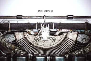 Old vintage typewriter, retro machine with white sheet of paper and typed text 