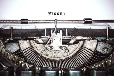 Old vintage typewriter, retro machine with white sheet of paper and typed text 