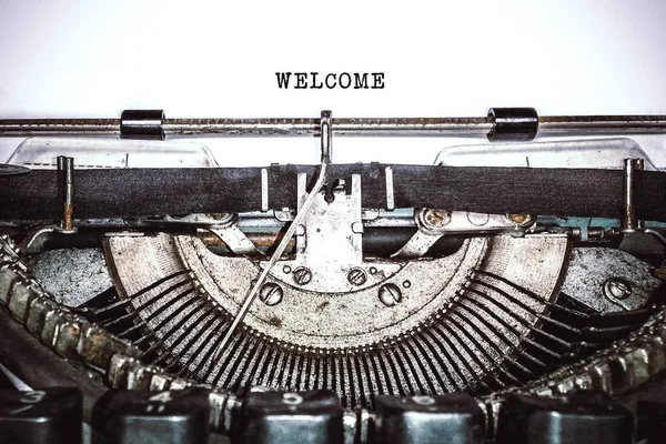 Old vintage typewriter, retro machine with white sheet of paper and typed text 