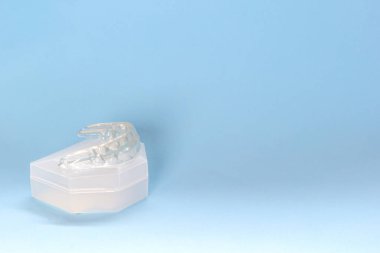 Silikon diş koruyucusu, ortodontik antrenör mavi arka plandaki ısırığı düzeltmek için, boşluğu kopyala