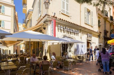 MONTE CARLO, MONACO - JUNE 10, 2014: Tourists walk along beautiful streets, promenade, sightseeing walk of Monte-Carlo in principality of Monaco, southern France