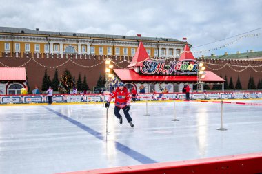 MOSCOW, RUSSIA - FEBRUARY 29, 2020: Happy people play hockey at rink on Red Square in Moscow, Russia clipart