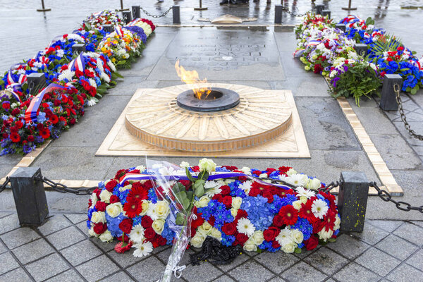 PARIS, FRANCE - MAY 8, 2019: Flowers and eternal flame near Arc de Triomphe in honor of victory over fascism in World War II on Place de Gaulle in Paris, France