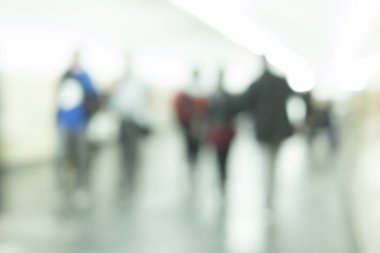 Yeraltı geçidinde yürüyen insanlar. Bulanık yolcu siluetleri. Taşınan insanların bulanık görüntüsü.