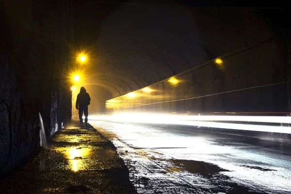 man going through the dark tunnel