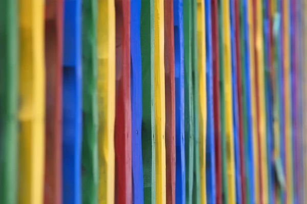 Cerca de madeira colorida. Uma cerca de madeira feita se varas coloridas — Fotografia de Stock