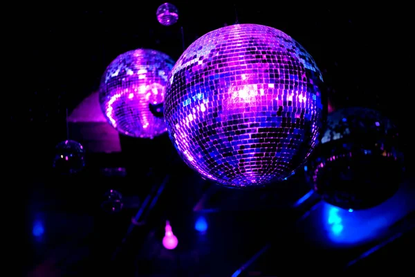 迪斯科舞会在一个蓝灯和紫灯的夜总会里举行 反射光和光束的镜像球 — 图库照片