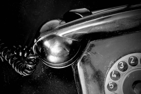 Винтажный стационарный телефон в черно-белом. Телефон в стиле ретро. Черный телефон с телефоном и кабелем. Винтажное офисное оборудование
.