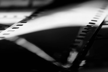 Görüntü yansımaları olan siyah-beyaz negatif film. 35 mm negatif film. Sığ alan derinliğine sahip fotoğraflı film görüntüsü.