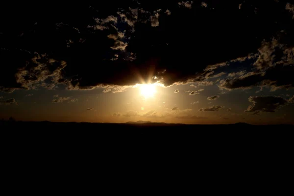 Ufukta bulutlar tarafından günbatımı yaktı — Stok fotoğraf