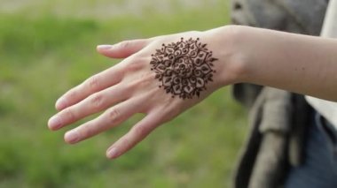 Kına dövme ile el atış kapatın. Güzel kız onun yeni çiçek mehendi kameraya gösterilen.