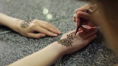 Kına bir tablo ile bir yandan çiçek mehendi yapma kadın.