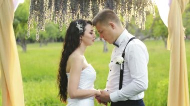 Adam güzel sevgilisi için aşk sözcükleri konuşma büyüleyici bir çiftin yakın çekim. Esmer kadın ve gelinlik kısa saçlı bir adam.