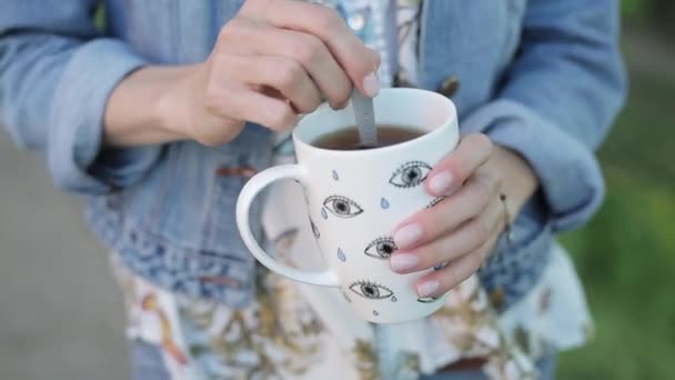 Girl mixing her beverage. Close up of a tea in a white cup. — Stock Video