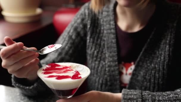 Woman eating panna cotta with a spoon — Stock Video
