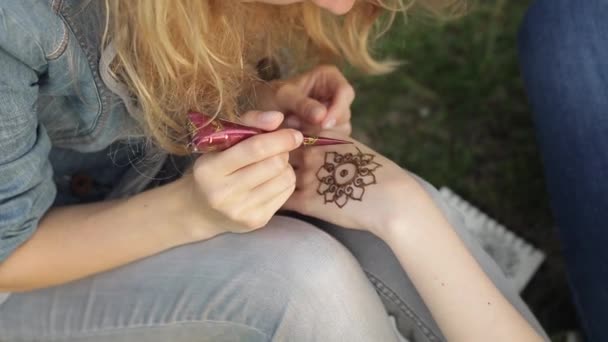 Mladá žena dělat květinové mehendi na ruce pomocí Henny.
