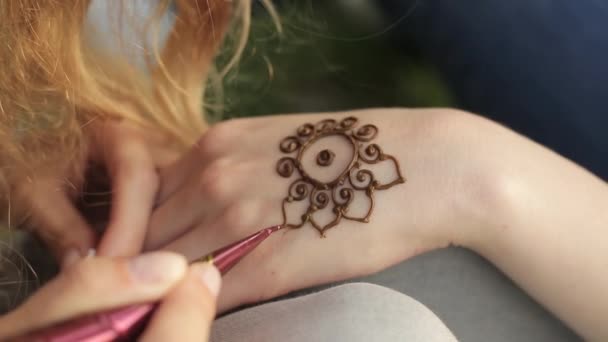 Молода жінка робить квітковий мехенді на руці за допомогою хни . — стокове відео