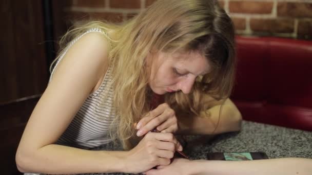 Жінка робить квітковий мехенді на руці з хною на столі . — стокове відео