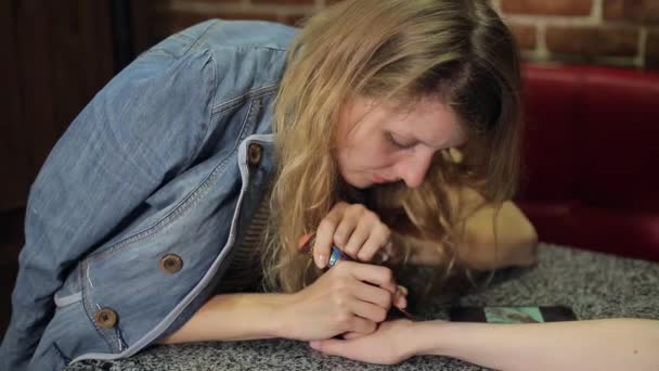 テーブルにヘナで手に花 mehendi を作る女性. — ストック動画