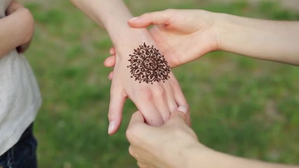 Handen van twee jonge Kaukasische meisjes met bloemen mehndi tatoeage. — Stockvideo