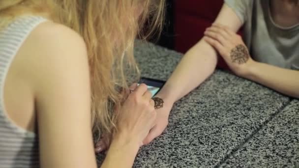 Mujer haciendo mehendi floral en una mano con henna en una mesa . — Vídeos de Stock