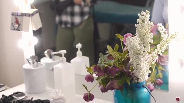 Workplace makeup artist or browmaker. A table, a bunch of colorful flowers, tongs, cotton swabs and liquids. — Stock Video