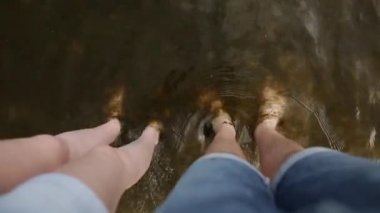 Genç çiftin birlikte denizde su kirli kum, plaj ayakta bacaklar. Çıplak ayak deniz yosunu ile kirli deniz suyu ayakta insan. Çevre kirliliği kavramı.