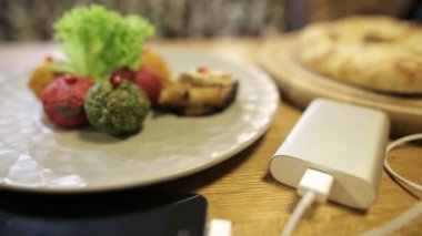 Cep telefonu ve Gürcü çanak pkhali taşınabilir pil şarj closeup çekim. Her zaman çalışan cep telefonu için kolay yol. Bir Usb güç bankadan şarj Smartphone. Gösterge yanıp söner
