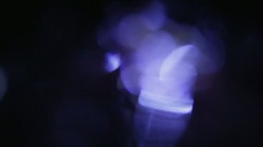 Renkli ışık darbeleri ve yanıyor. Güzel mavi ışık sızıntısı ile koyu arka plan üzerinde. Gerçek objektif mercek parlamaları soyut hareket arka plan için mükemmel.