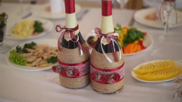 Boda botellas de champán cremoso y de color rojo hecho a mano en el restaurante . — Vídeo de stock