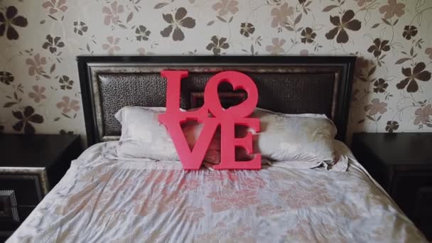 Valentinky den pozadí. Láska červenými písmeny na posteli pro valentinky den a Vánoce.