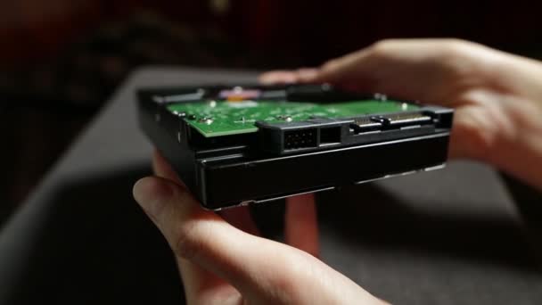 L'hard disk chiude i filmati delle scorte. Mani femminili che mostrano la parte inferiore di un disco rigido con connessioni e circuito stampato . — Video Stock