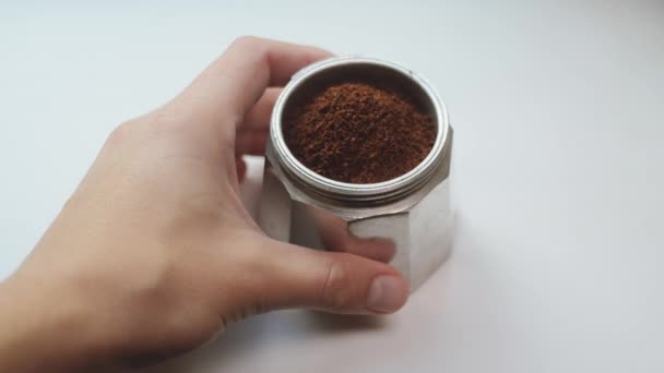 La mano maschile si spinge la parte inferiore della caffettiera italiana piena di arabica di caffè recentemente macinata o robusta. Una porzione di caffè profumato e tonificante in moka pot . — Video Stock