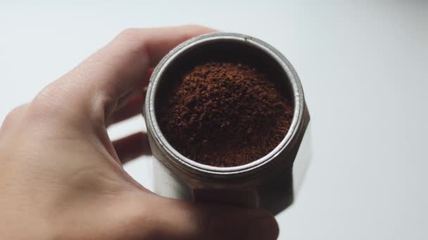 Demostración de la molienda correcta de café para la cafetera italiana. Moka olla con café molido tostado oscuro en mano humana . — Vídeos de Stock