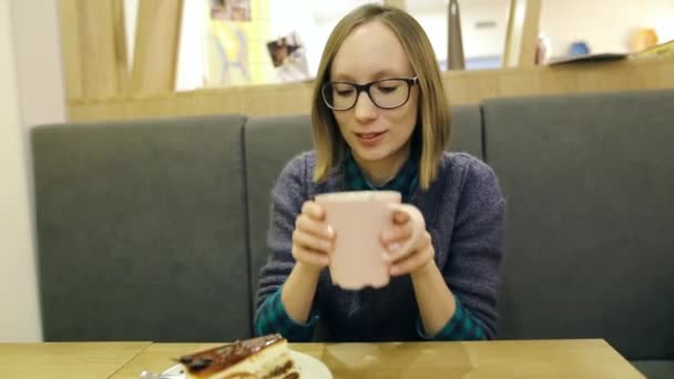 Menina bonita nova em óculos menina sorrimaced depois de tentar chá insípido em um café. O cliente insatisfeito fica chocado com a qualidade do serviço e o sabor da comida no restaurante. . — Vídeo de Stock